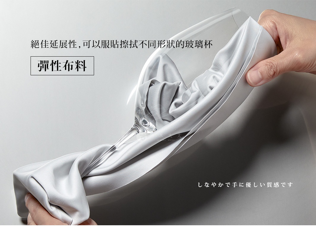 一隻手拿著一塊銀灰色、柔軟光滑的超細纖維布，布料纏繞著一個玻璃杯的杯身，展現其優異的延展性。