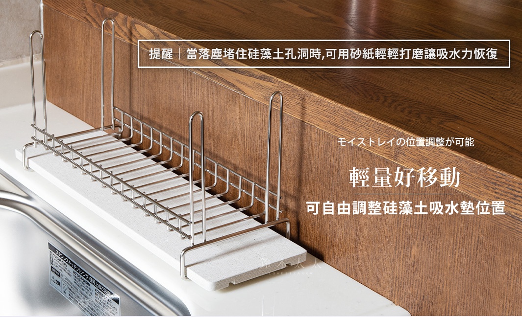 銀色金屬網架，下方搭配淺灰色珪藻土吸水墊，放置於木紋檯面及白色檯面交界處，設計簡潔實用。