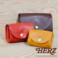 三款職人手作皮革三層收納零錢包，分別為紅色、黃褐色與深棕色，皆採用壓釦設計，展現皮革紋理與質感。