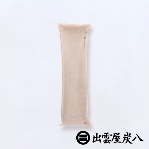 淺米色長條形木炭包，外層為無紡布材質，中央有細線縫合，頂部有封口，印有品牌標誌與中文「出雲屋炭八」，適合用於櫥櫃。