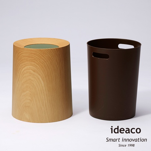 兩個家用垃圾桶，一個為淺木紋色，圓柱形，頂部開口；另一個為深棕色，圓柱形，兩側有橢圓形提把。