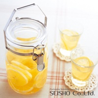 透明玻璃密封儲物瓶，瓶內裝有檸檬切片和黃色液體，瓶蓋配有銀色金屬提把與扣環。