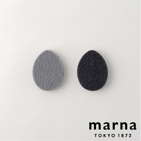 marna TOKYO 1872 品牌標誌旁有兩個橢圓形的去茶垢專用菜瓜布，分別為灰色和黑色。