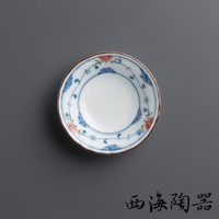 一個陶瓷小圓碟，碟面為白色，邊緣飾有藍色花紋及紅色花朵圖案，碟邊緣處有棕色細線。