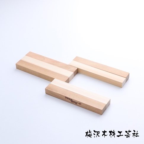 三塊木製隔熱墊，由不同深淺的淺色木材拼接而成，呈長條狀，其中一塊有「TOSAYU」字樣。