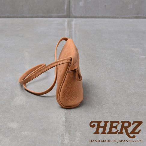 HERZ 職人手作皮件，駝色皮革斜背包，附細長可調式背帶，包身圓潤飽滿，展現皮革溫潤質感。