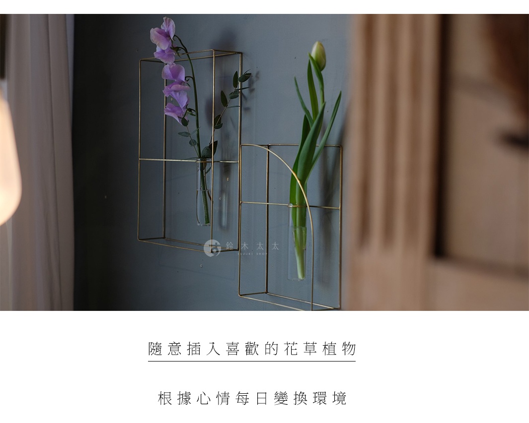 黃銅書本造型掛擺兩用花器，包含兩個長方形金屬框架，內嵌玻璃試管，分別插有紫色花朵與綠色花苞。