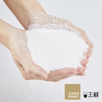 雙手捧著大量白色細小顆粒，部分顆粒散落在手上，呈現出蓬鬆的質感，背景為淺色。