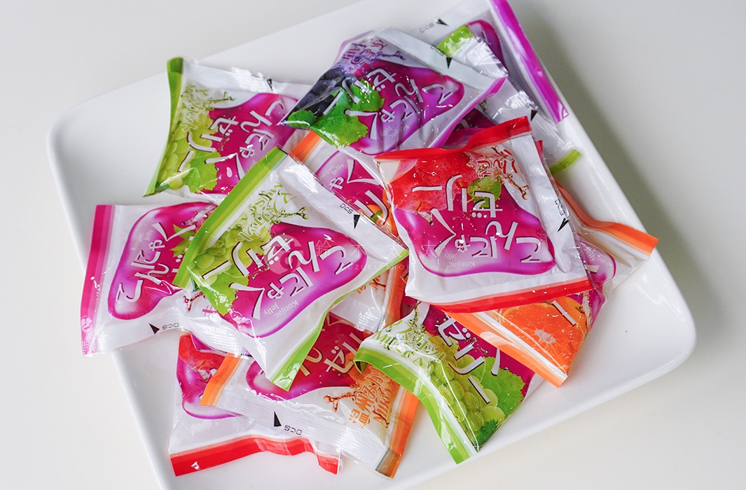 一堆色彩繽紛的雪國蒟蒻果凍小包裝，堆疊在白盤上