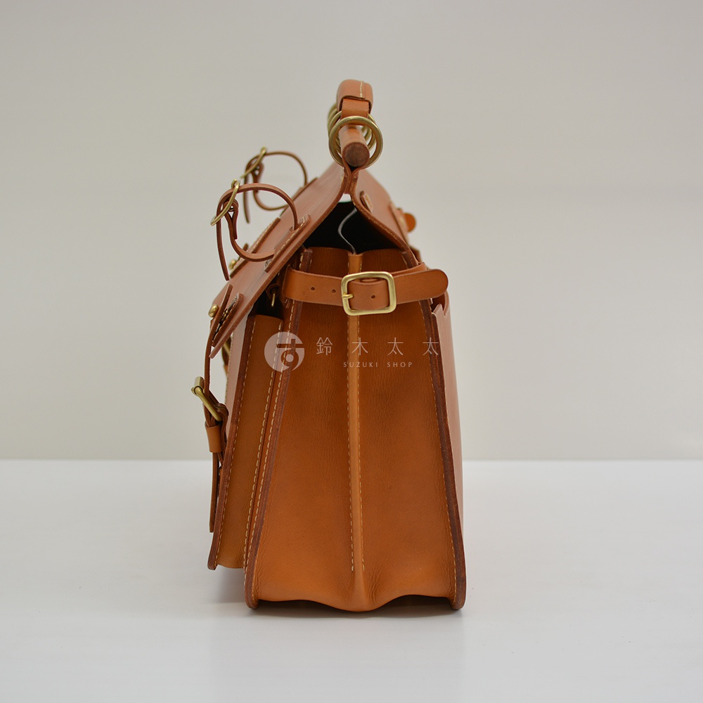 職人手作皮革旅行包 A-102，採用鞣製皮革製成，呈現經典棕褐色。包款側視，可見多層結構、金屬釦環、皮帶扣及提把，整體設計簡潔大方，適合旅行使用。