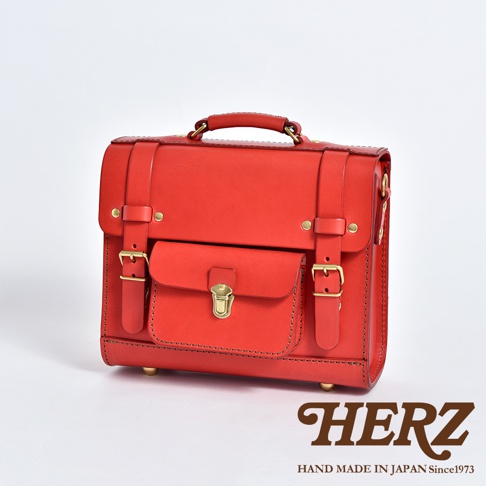 鮮紅色皮革學院風迷你後背包，設有翻蓋前袋、可調節搭扣帶及頂部提把，搭配金色金屬配件。