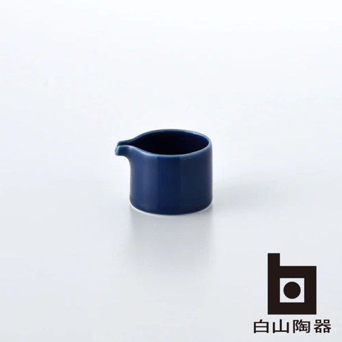 藍色陶瓷 M 型糖盅，帶有傾倒嘴，置於白色背景上。