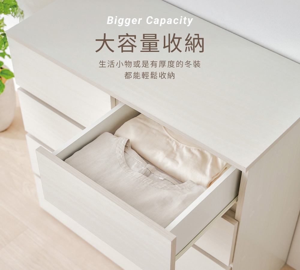 一個淺木紋色系的IRIS OHYAMA木製收納櫃，從高處俯視角度拍攝，其中一個抽屜被拉開，裡面整齊擺放著兩件衣物，圖片上方標示著大容量收納的文字說明，強調此收納櫃能輕鬆存放生活小物或厚重冬裝。