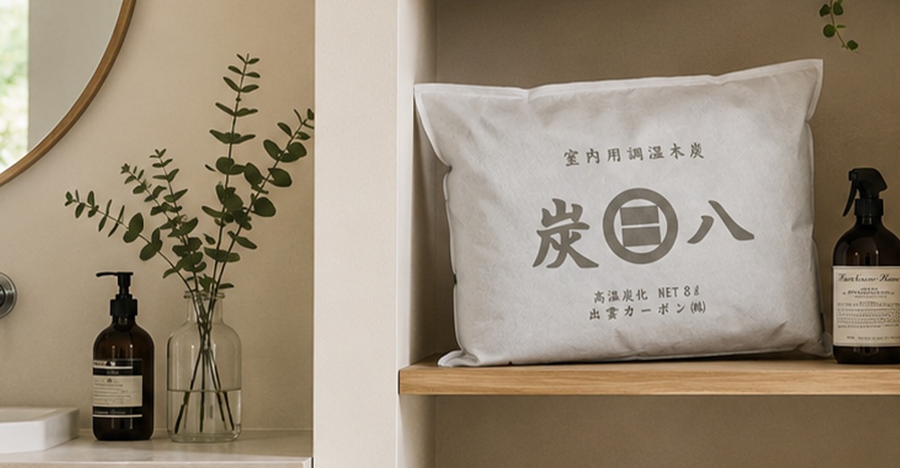 這張照片呈現了室內居家擺設，木質層架上放置了一包白色的炭八室內用調濕木炭，旁邊擺放著噴霧瓶與一瓶裝有綠色植栽的透明玻璃花瓶，背景為簡潔雅緻的淺色牆面，整體風格清新自然且具備除濕功能。