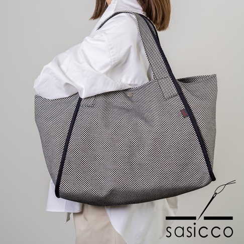 一款由黑白細格紋三河木綿刺子織製成的可變形大容量托特包，配有深藍色滾邊和同色系織帶。