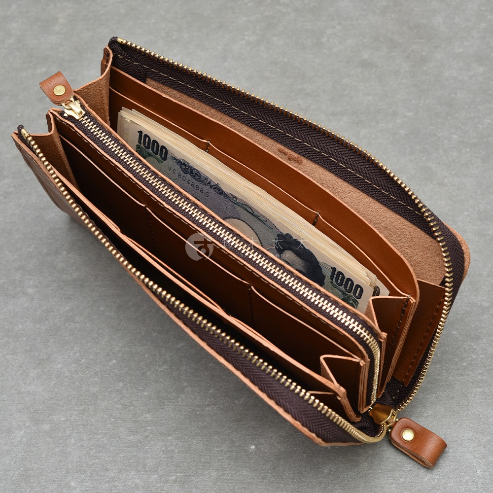 職人手作皮革Organ大容量拉鍊長夾，棕色皮革，拉鍊開合，內部可見一疊日圓鈔票，多個夾層設計。