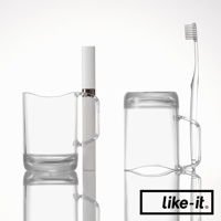 兩個透明塑膠漱口杯，一個杯內放置白色牙膏，另一杯倒置，旁邊立著一支透明塑膠牙刷。