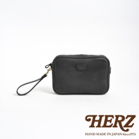 黑色皮革手提包，附可拆式手腕帶，正面有圓形品牌標誌，採用拉鍊開合。