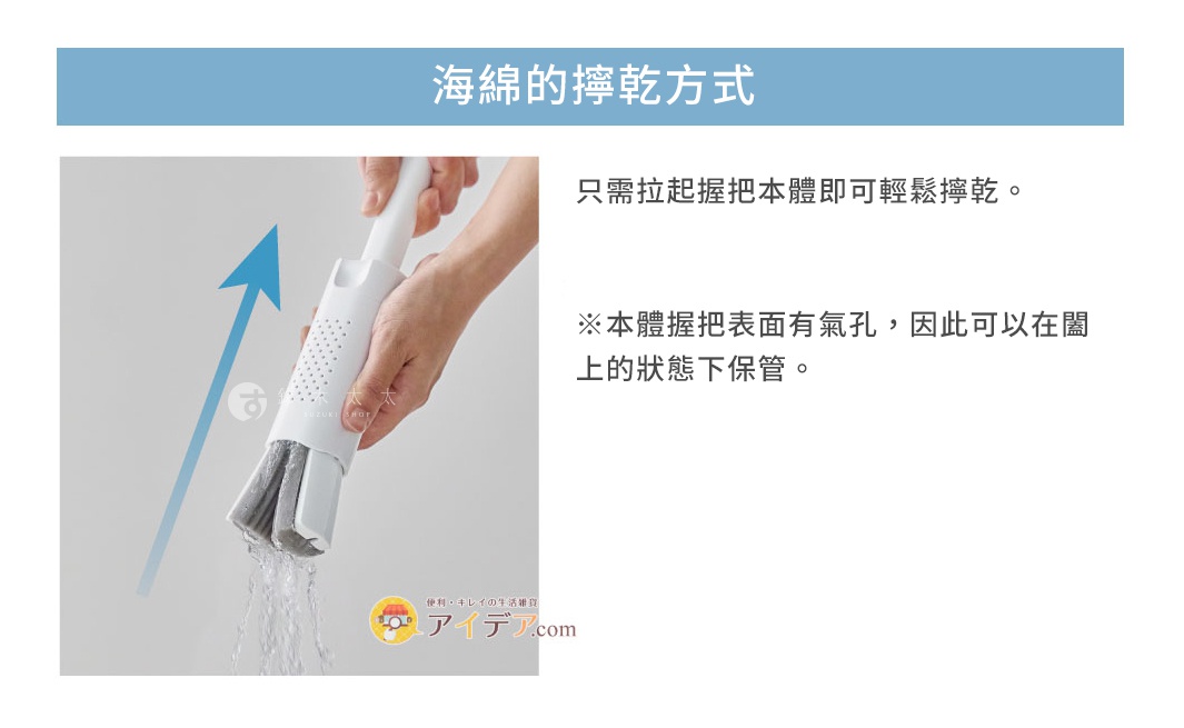 手持白色塑膠柄清潔刷，刷頭為灰色海綿，正在進行瀝水動作，有水珠滴落。