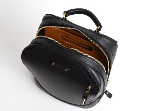 黑色皮革直式收納袋中袋，拉鍊式開合，內襯為棕色皮革。