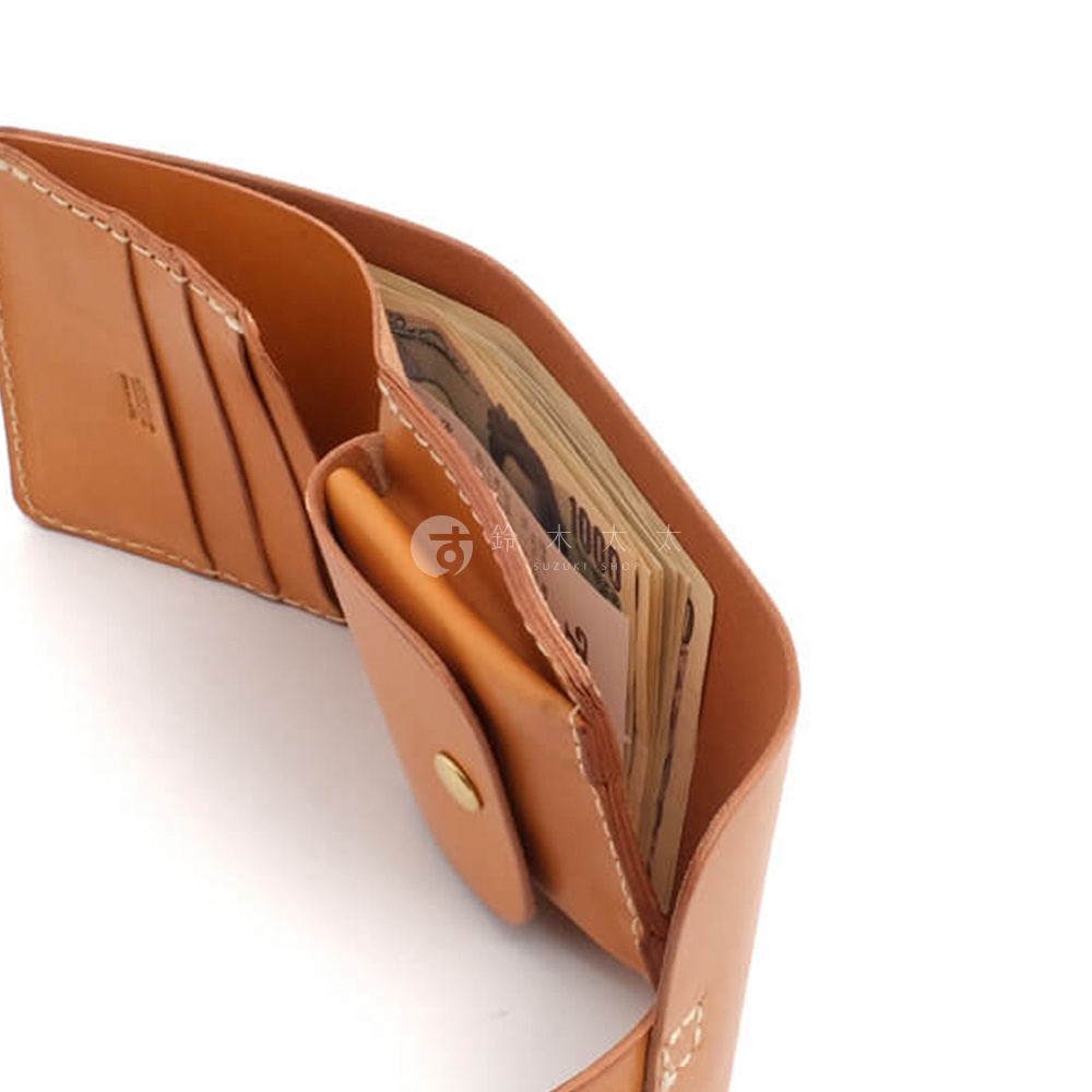 職人手作皮革原子釦型二折式短夾，展示其淺棕色皮革材質、縫線細節，以及內含日圓鈔票的設計。
