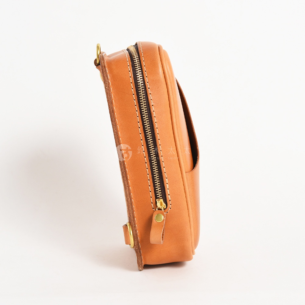 日本 HERZ 職人手作皮革兩用直立型斜背包，特寫展示包包側邊的皮革材質、拉鍊細節及金屬配件。