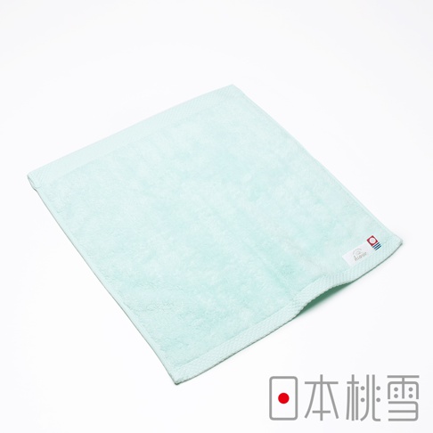 一塊淺綠色的今治超長棉方巾，材質柔軟，表面有細緻的紋理，角落處有一個包含品牌標誌和日文「今治」字樣的小標籤。