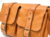 職人手作皮革水洗加工前雙口袋肩背包，淺棕色，採用植物鞣革製成，設有兩個帶有金屬釦的翻蓋前袋，以及可調節的皮革肩帶。