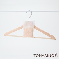 純天然防潮消臭檜木除濕包 M，裝有淺棕色檜木碎屑，懸掛於淺木色衣架上，衣架掛在白色掛桿上。