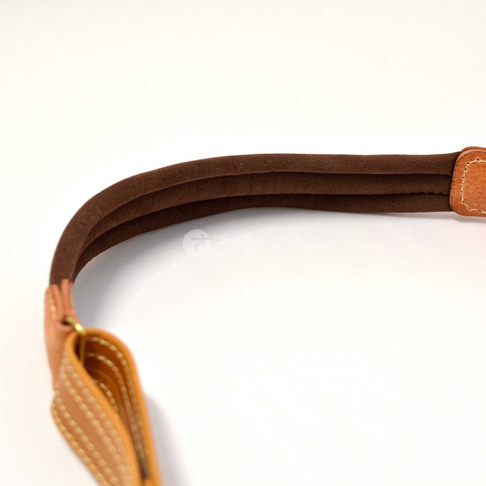 職人手作皮革鹿角扣繩郵差包 W-3 的棕色絨面革加厚提把，搭配淺棕色皮革，縫線細緻。