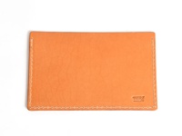 淺橙色皮革製成的存摺文件收納夾，邊緣有白色縫線，右下角壓印有「HERZ」和「MADE IN JAPAN」字樣。