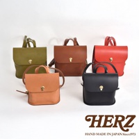 五款職人手作皮革翻蓋迷你後背包，顏色包含：卡其綠、棕色、橘棕色、紅色、黑色。皆為皮革材質，設計簡約，配有金色旋轉鎖扣。