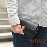 黑色皮革手風琴式長夾，配有金色鎖扣和拉鍊，由手工製作。