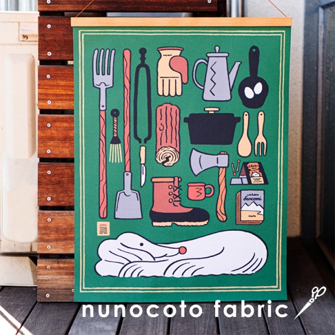 綠色帆布海報，印有露營主題圖案，包括鍋具、靴子、柴火、斧頭、手套、餐具及一隻熟睡的白色動物。