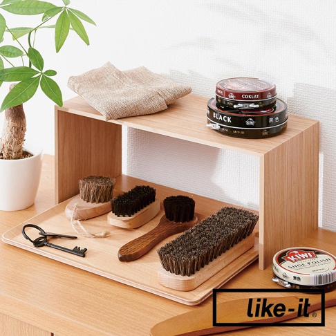 木紋雙層收納架，展示有鞋刷、鞋油罐、鑰匙和麻布袋，架上放置兩罐鞋油。
