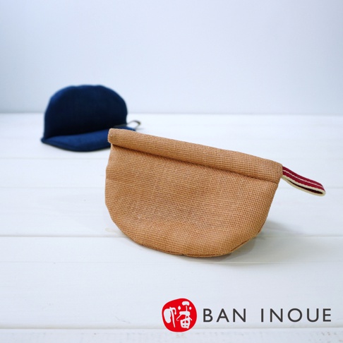 兩個防燙鍋套，一個為卡其色粗織布紋理，帶有紅白色條紋織帶；另一個為深藍色。