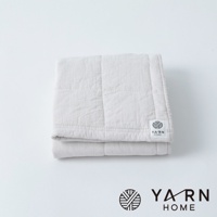 淺米色格紋毛巾，材質為脫脂棉混紗，表面有縫線紋路，右下角有品牌標籤。