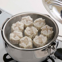 不鏽鋼料理濾網置於鍋中，網籃內擺放著八個蒸熟的燒賣，燒賣外皮呈現白色，內餡為肉末。