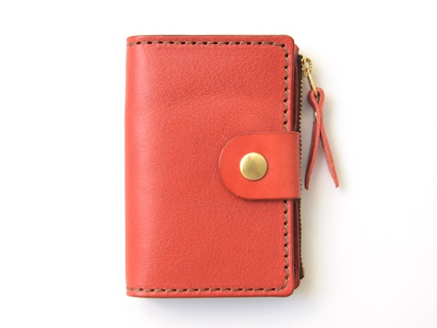 職人手作橘紅色皮革拉鍊零錢鑰匙包，設有啪鈕開合及金屬拉鍊，皮革質感良好，車縫線工整，附有皮革拉鍊頭。
