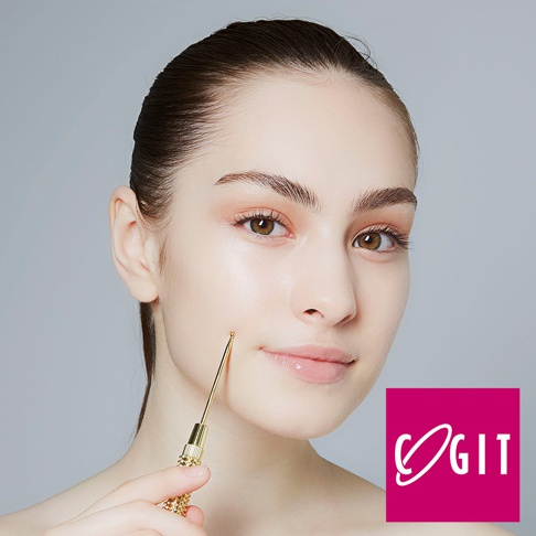 一位女性將金色滾輪提拉器輕觸臉頰，滾輪手柄上有精細的紋飾。