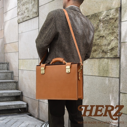 職人手作皮革兩用機師箱，經典棕色，搭配金色鎖扣與提把，質感皮革製作，適合商務及日常使用。