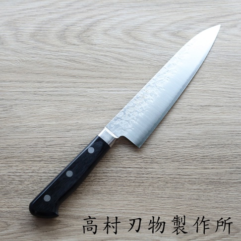 VG10不鏽鋼材質的18公分牛刀，刀刃表面有細緻的鎚目紋路，搭配黑色握柄，整體呈銀色與黑色。