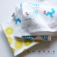 白色毛巾堆疊，其中一條印有黃色檸檬片圖案，另一條印有藍色和紅色小雞圖案，材質輕薄透氣，觸感柔軟。