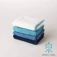 SOLID 細柔蓬韌緞澤長纖迷你浴巾，堆疊展示，從上至下為白色、淺藍色、藍色、深藍色，皆為純色，邊緣有滾邊設計。