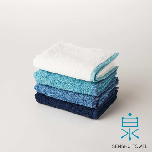 SOLID 細柔蓬韌緞澤長纖迷你浴巾，堆疊展示，從上至下為白色、淺藍色、藍色、深藍色，皆為純色，邊緣有滾邊設計。