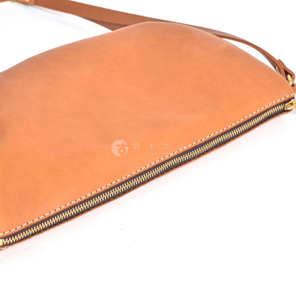 日本HERZ職人手作皮革半圓馬鞍包CK-17，棕褐色皮革材質，獨特的拉鍊細節，特寫視角。