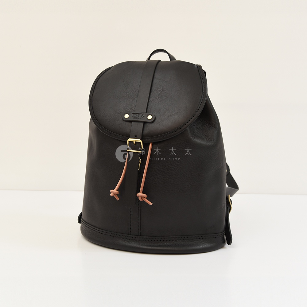 黑色皮革單扣束口後背包，設有可調節束繩和金色金屬扣環，展現簡約設計。