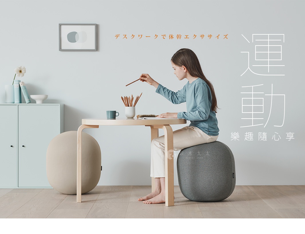 一個女孩坐在灰色針織彈力平衡球上，旁邊有一個米色彈力平衡球。