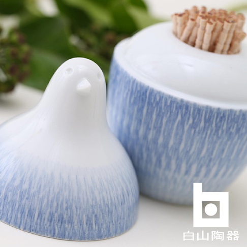 陶瓷製的白鳥造型牙籤瓶，瓶身飾有藍色條紋，瓶蓋上插滿牙籤。