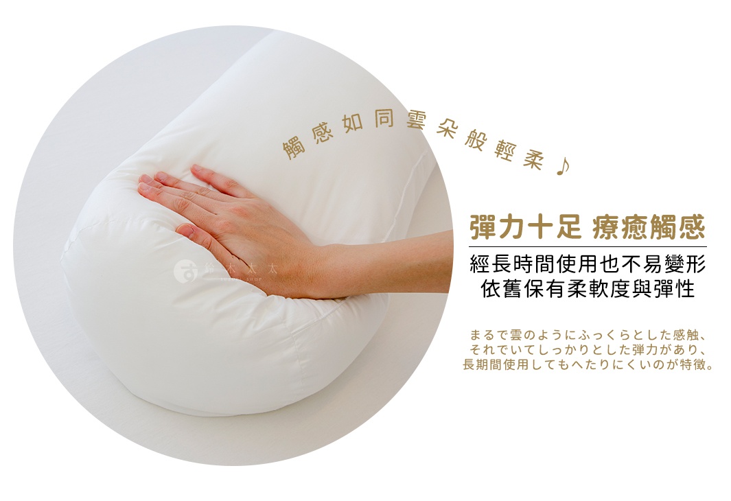 白色圓柱形夾腿枕，表面為光滑布料，內部填充物飽滿，一隻手正在按壓枕頭，展示其柔軟度和彈性。